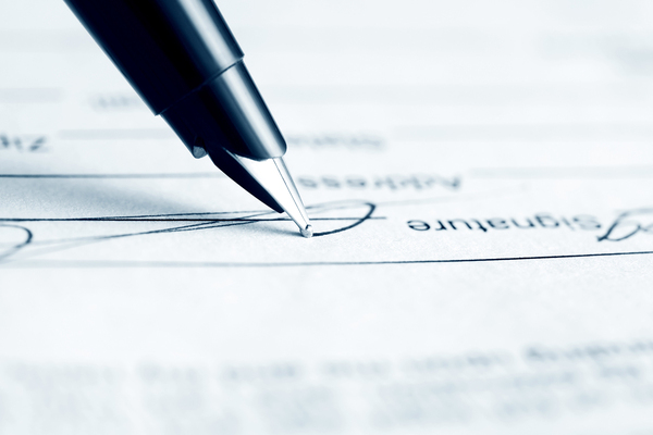 expensive pen finishing a signature on a paper