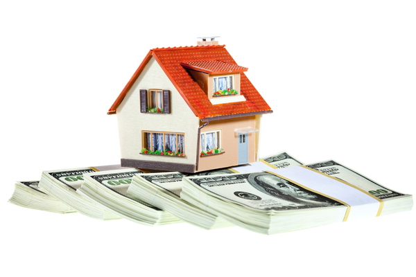 toy house with stacks of hundred dollar bills